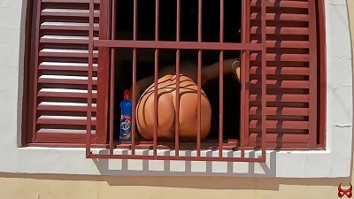 A scantily clad woman is discovered cleaning a window without clothes