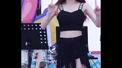 Beautiful woman dancing in public, wearing a short skirt.